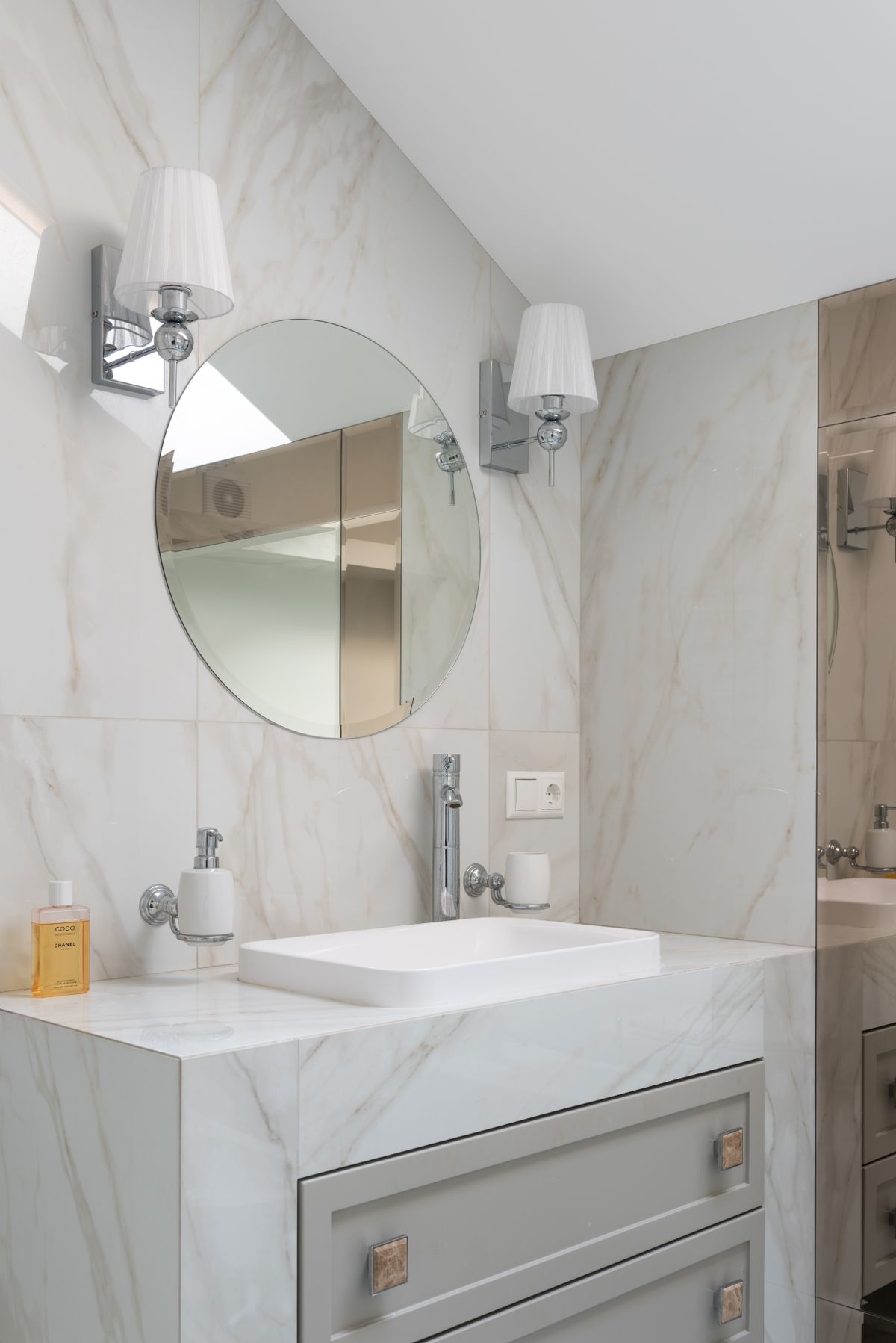 A bright bathroom vanity framed by warm marble