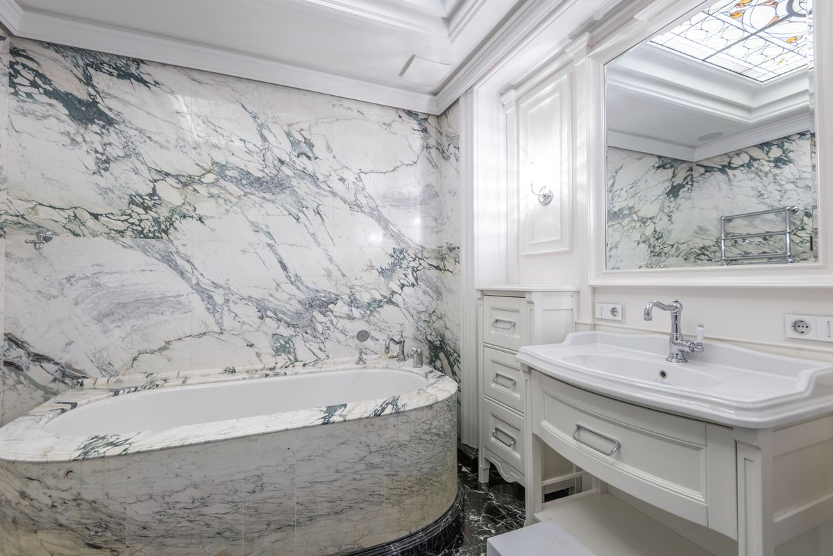 A luxury bathroom with white marble tile walls and floor