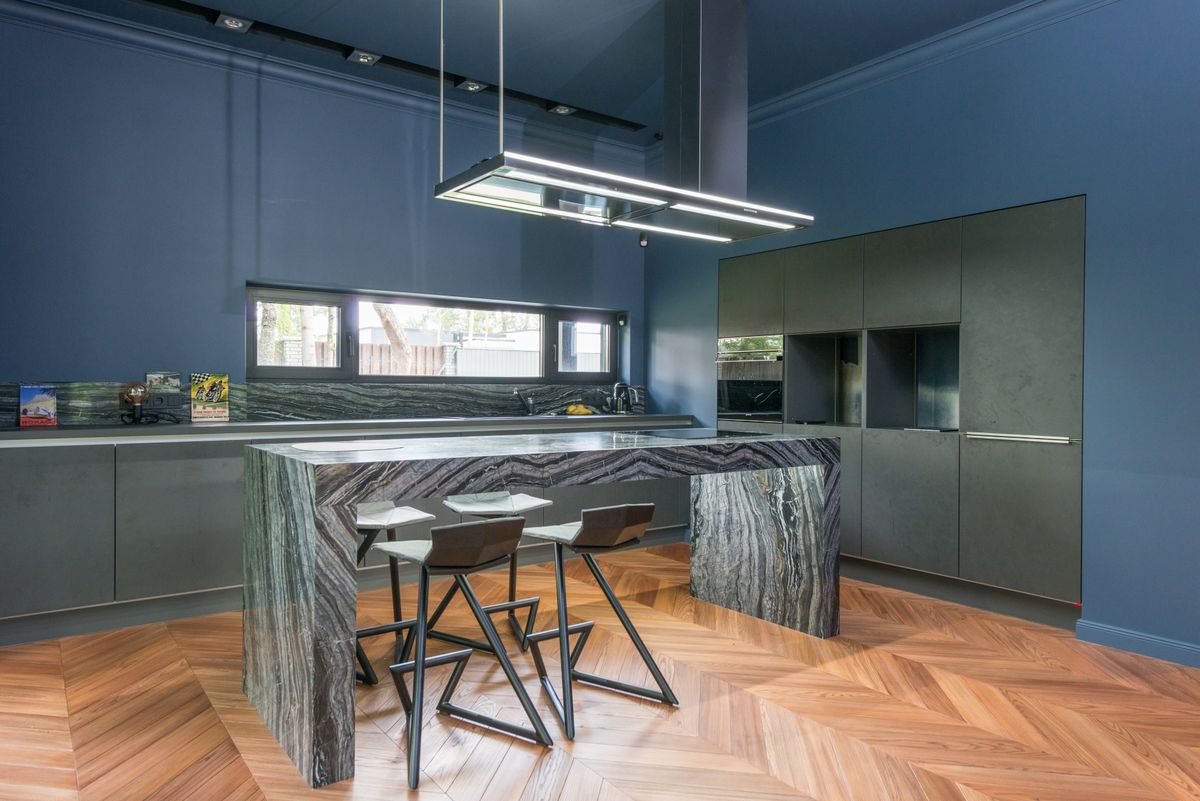 A large kitchen island with a waterfall stone edge and bar seating
