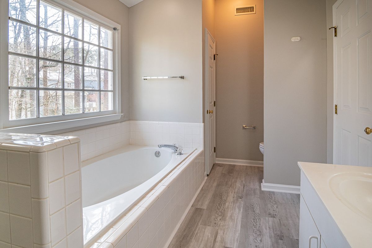 A large window floods an older bathroom with natural light
