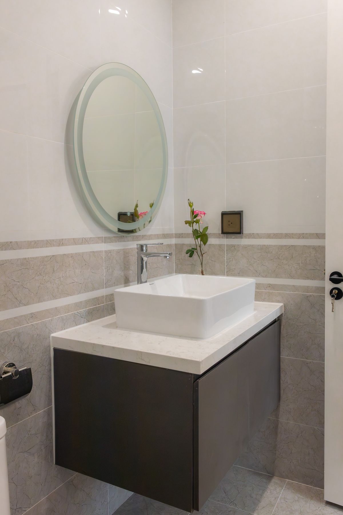 A wall-mounted vanity scaled to a compact older bathroom