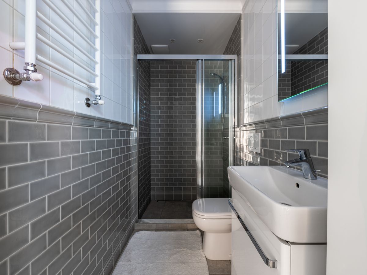 A walk-in shower with classic gray subway tile